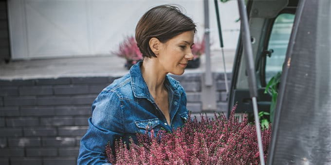 Autoversicherung Firmenkunden Eine Frau trägt Blumen