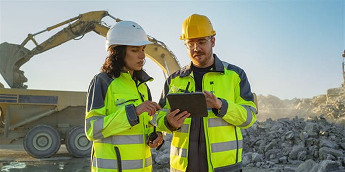 Eine Frau und ein Mann unterhalten sich auf der Baustelle Eine Frau und ein Mann unterhalten sich auf der Baustelle
