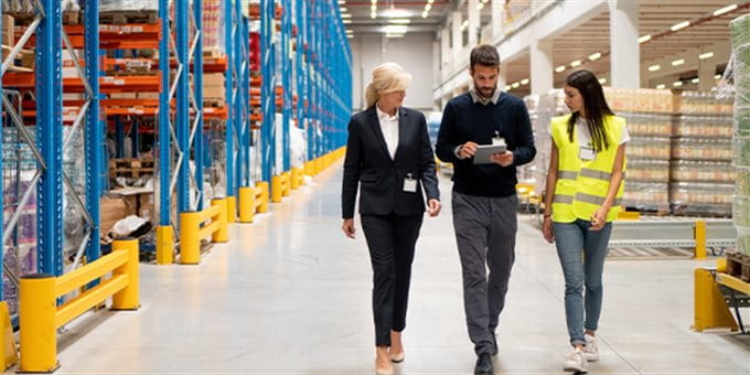 Zwei Frauen und ein Mann gehen durch ein Lager Zwei Frauen und ein Mann gehen durch ein Lager