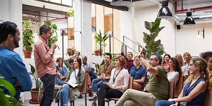 Ein Mann spricht vor einer Gruppe Ein Mann spricht vor einer Gruppe