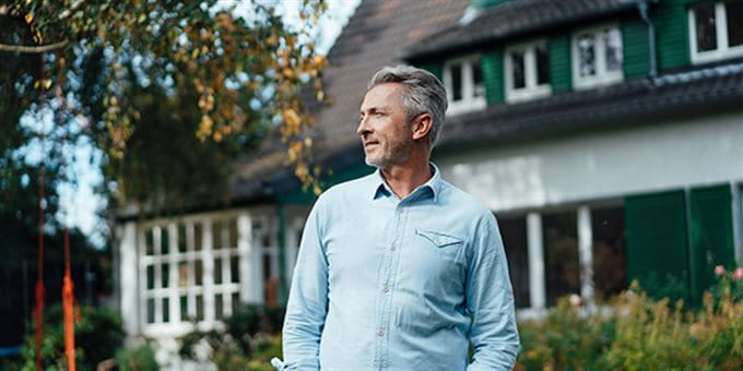 Mann im Garten seines Hauses Mann im Garten seines Hauses
