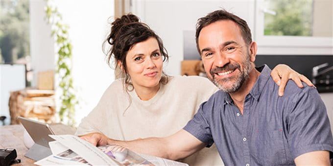 Frau und Mann lesen am Tisch die Zeitung Frau und Mann lesen am Tisch die Zeitung