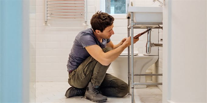 Handwerker Sanitär im Badezimmer am reparieren des Ablaufs Handwerker Sanitär im Badezimmer am reparieren des Ablaufs