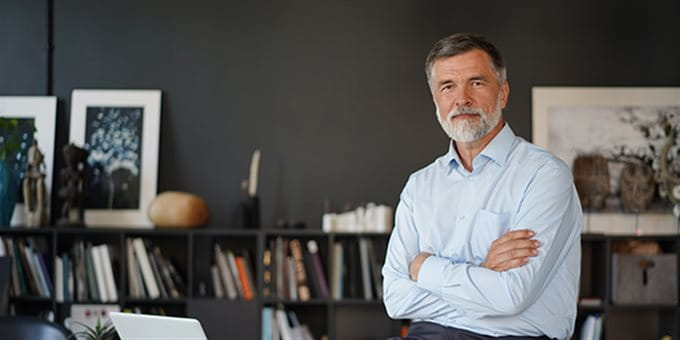 Mann im Büro mit verschränkten Armen Mann im Büro mit verschränkten Armen