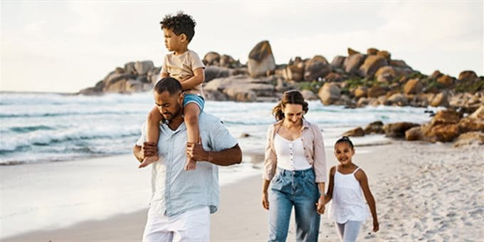 Familienpaar läuft auf Sandstrand mit 2 Kindern Familienpaar läuft auf Sandstrand mit 2 Kindern