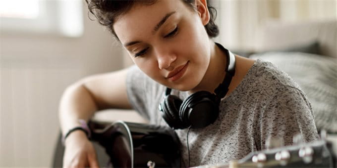 Jugendlicher spielt auf seiner wertvollen Gitarre Jugendlicher spielt auf seiner wertvollen Gitarre