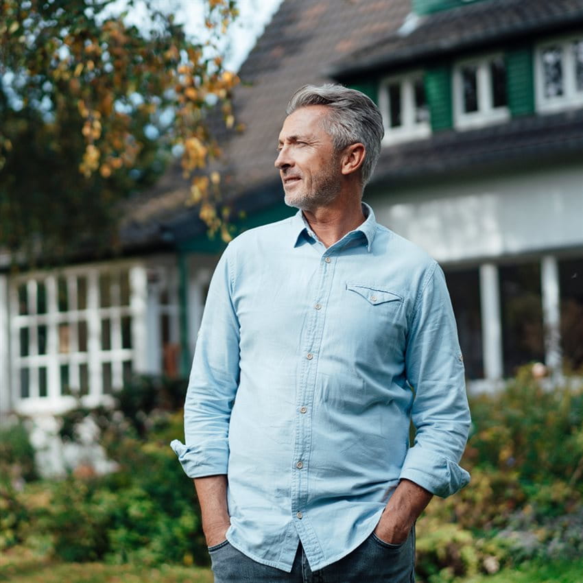 Mann im Garten seines Hauses Mann im Garten seines Hauses