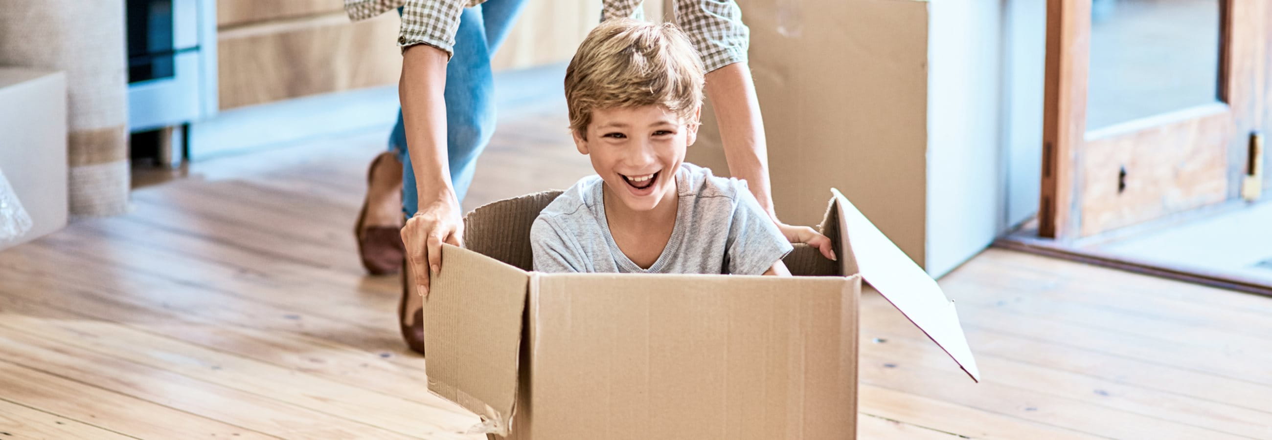Kind sitzt in Umzugskarton Kind sitzt in Umzugskarton