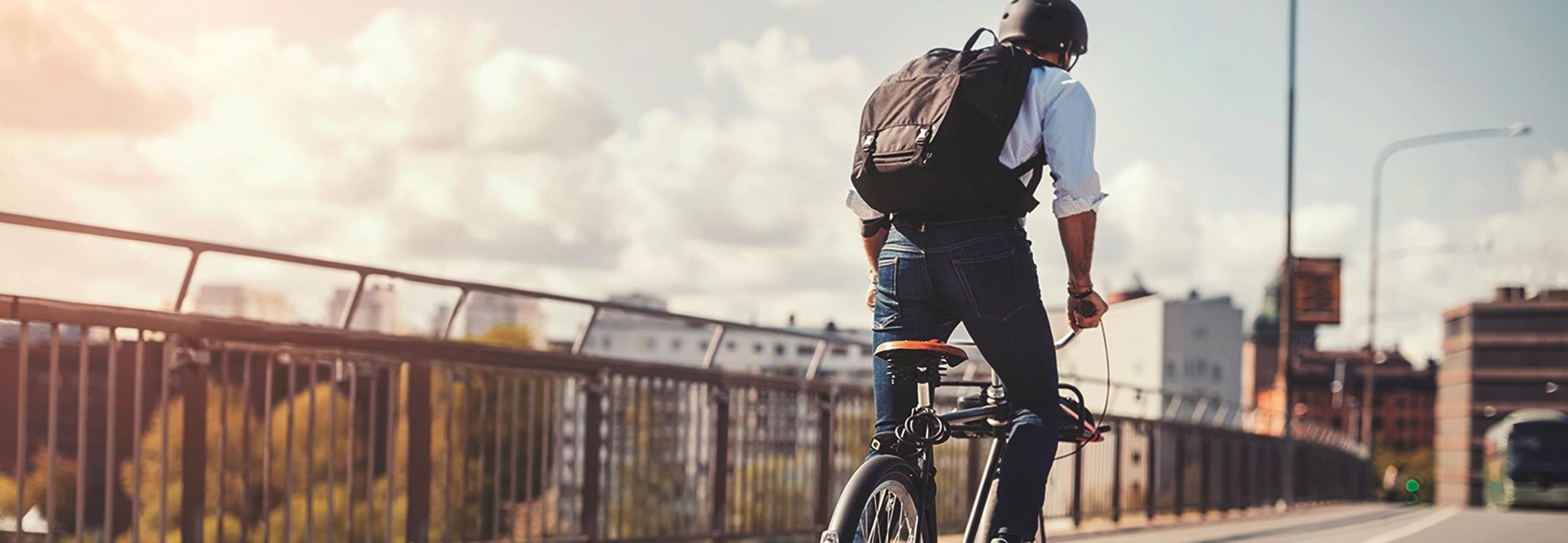 Mann fährt auf einem Fahrrad über eine Brücke Mann fährt auf einem Fahrrad über eine Brücke