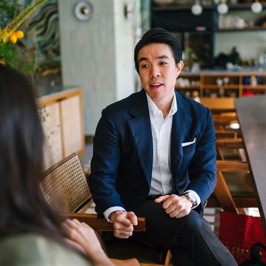 Un homme est assis sur une chaise et discute Un homme est assis sur une chaise et discute