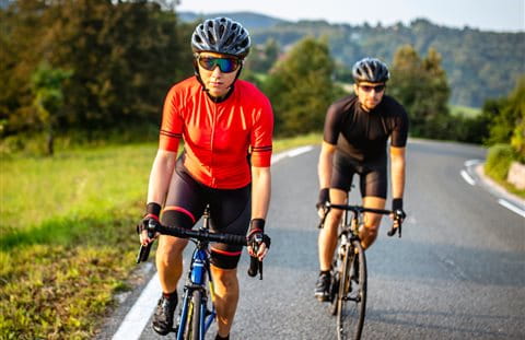 Two racing cyclists ride up the mountain Two racing cyclists ride up the mountain