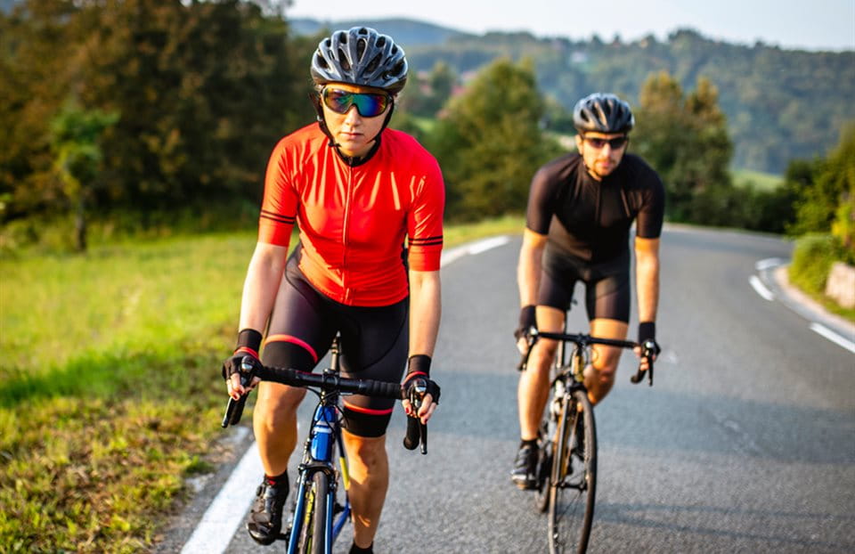 Two racing cyclists ride up the mountain Two racing cyclists ride up the mountain