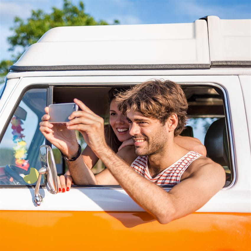 A person is taking a photo from the window of an orange vehicle. A person is taking a photo from the window of an orange vehicle.
