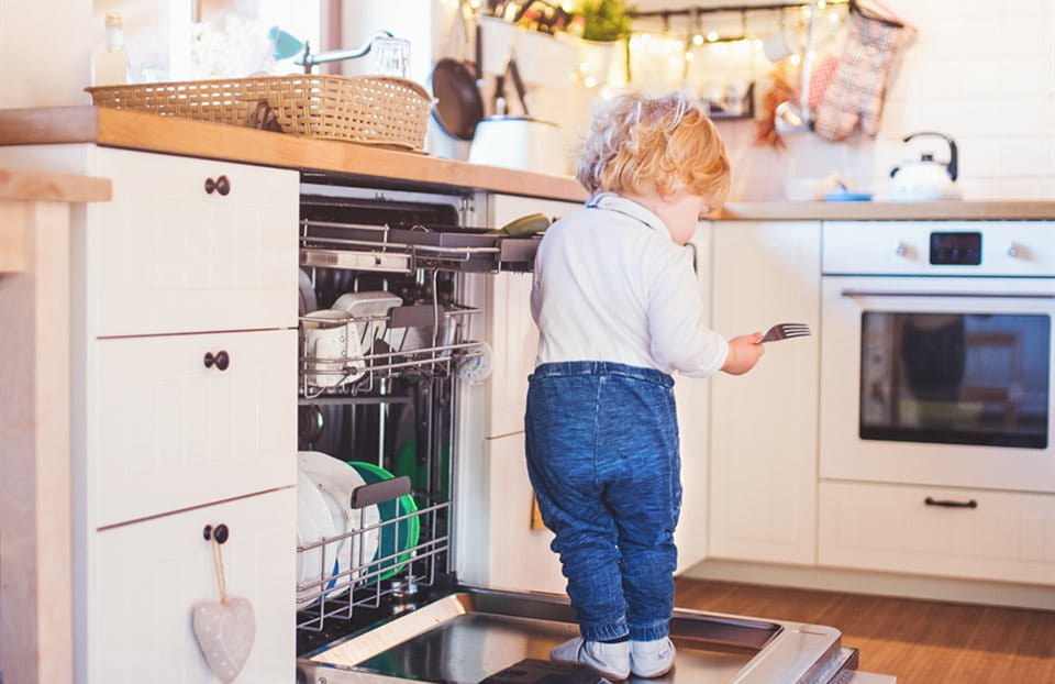 A child standing on the dishwasher door A child standing on the dishwasher door