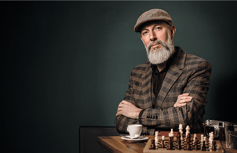 Uomo anziano ben vestito con una scacchiera Uomo anziano ben vestito con una scacchiera