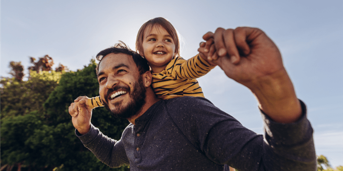 Erwachsener trägt Kind auf den Schultern im Freien. Erwachsener trägt Kind auf den Schultern im Freien.