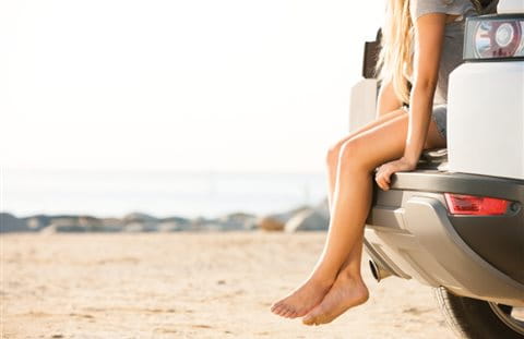 Junge Frau sitzt im Kofferraum eines Autos Junge Frau sitzt im Kofferraum eines Autos