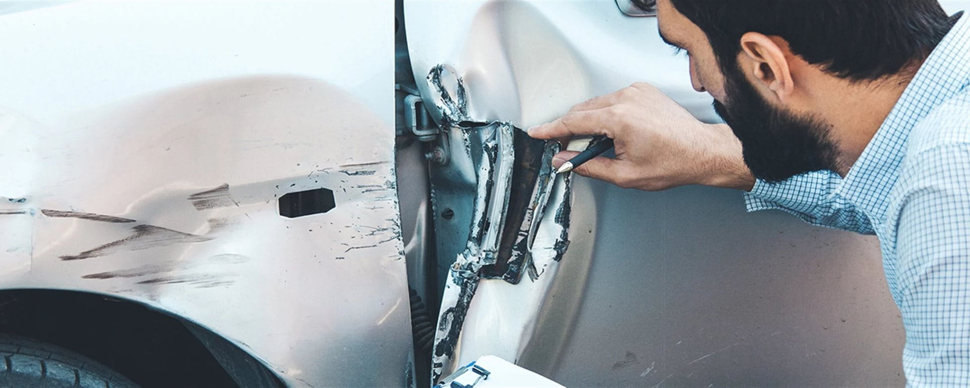 Man examines damage to the vehicle Man examines damage to the vehicle