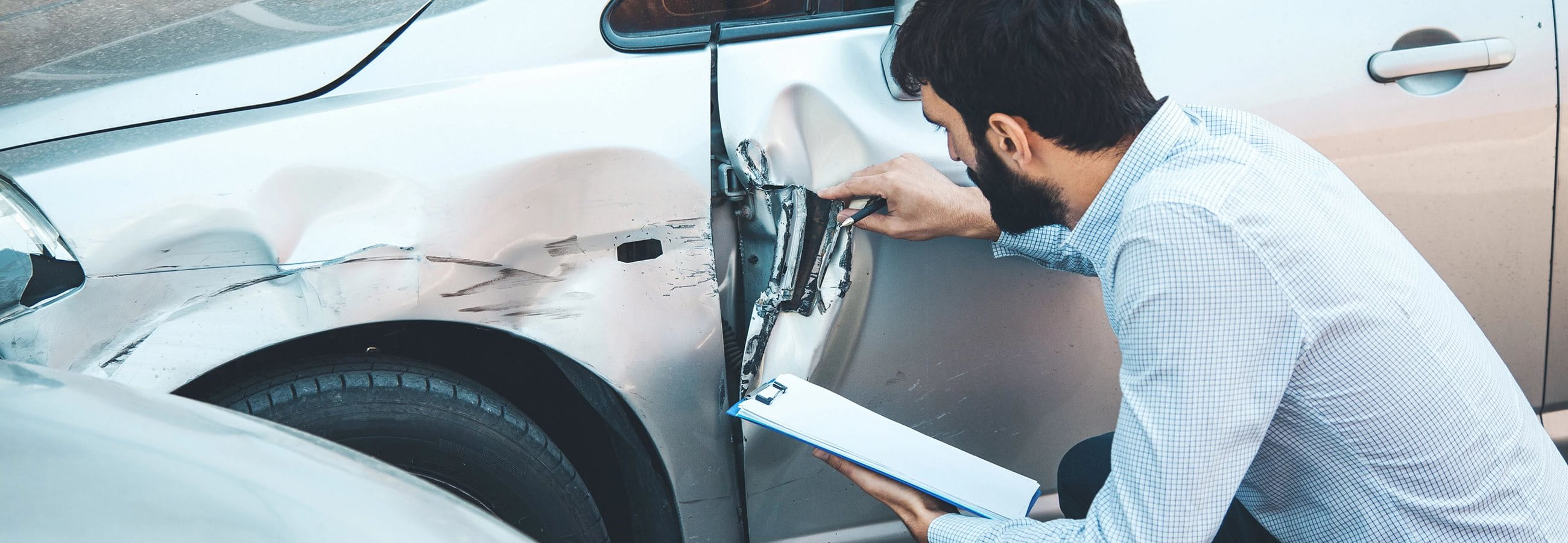 Man examines damage to the vehicle  Man examines damage to the vehicle