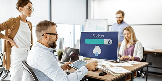 Employees confer and look at a computer screen Employees confer and look at a computer screen
