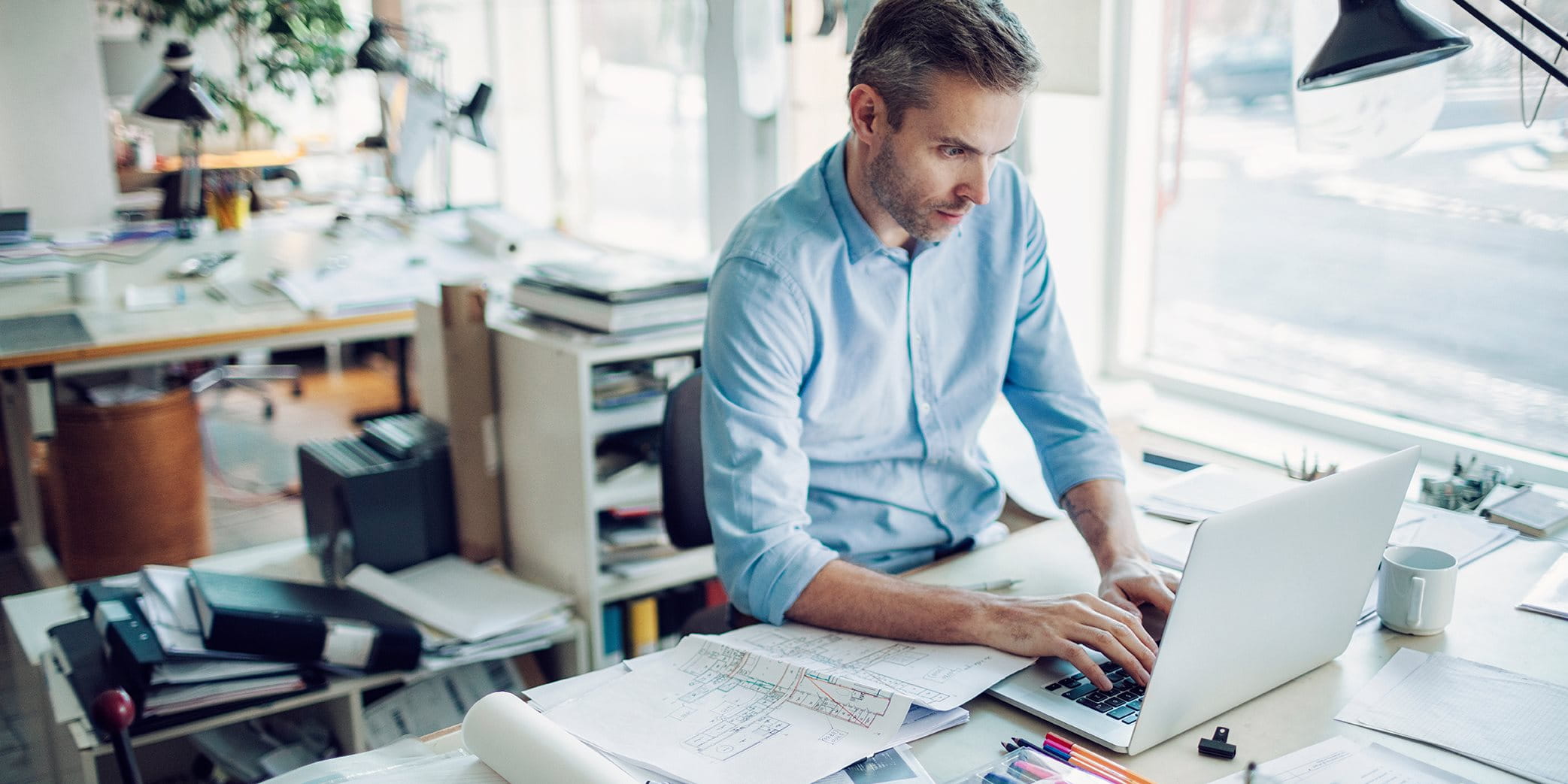 A man sits at his desk in an office A man sits at his desk in an office