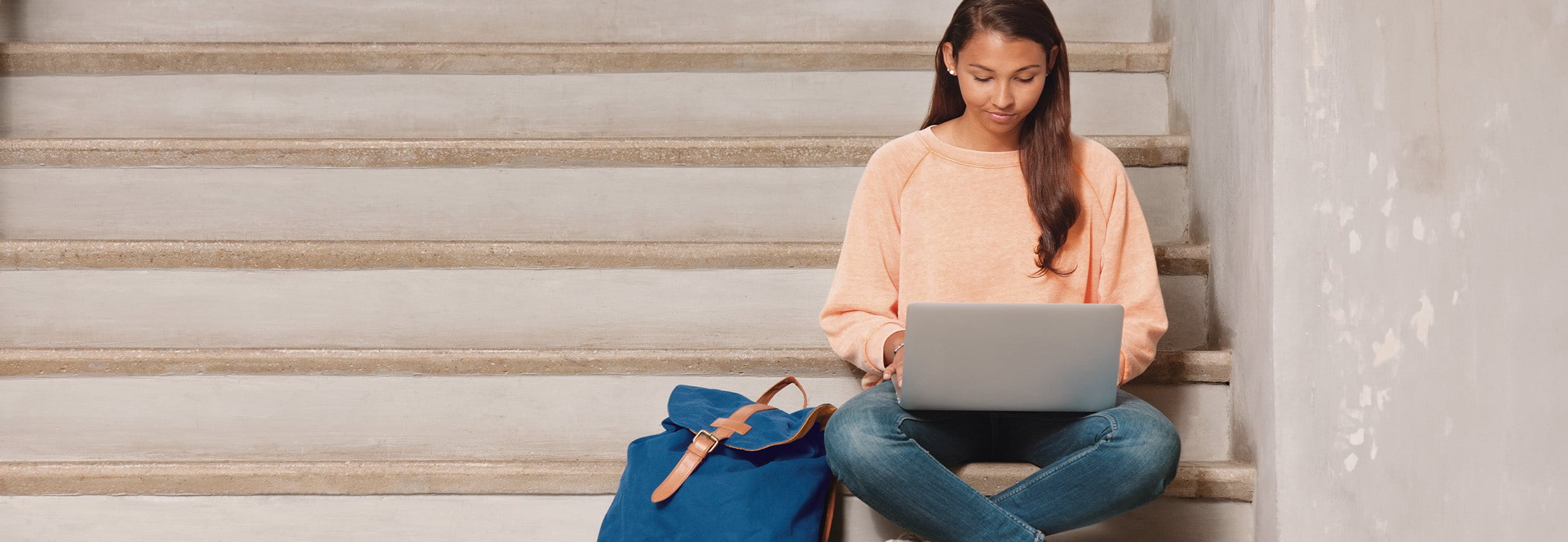 Young woman sitting on a staircase at the laptop Young woman sitting on a staircase at the laptop