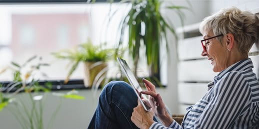 Una donna è seduta per terra con un tablet Una donna è seduta per terra con un tablet