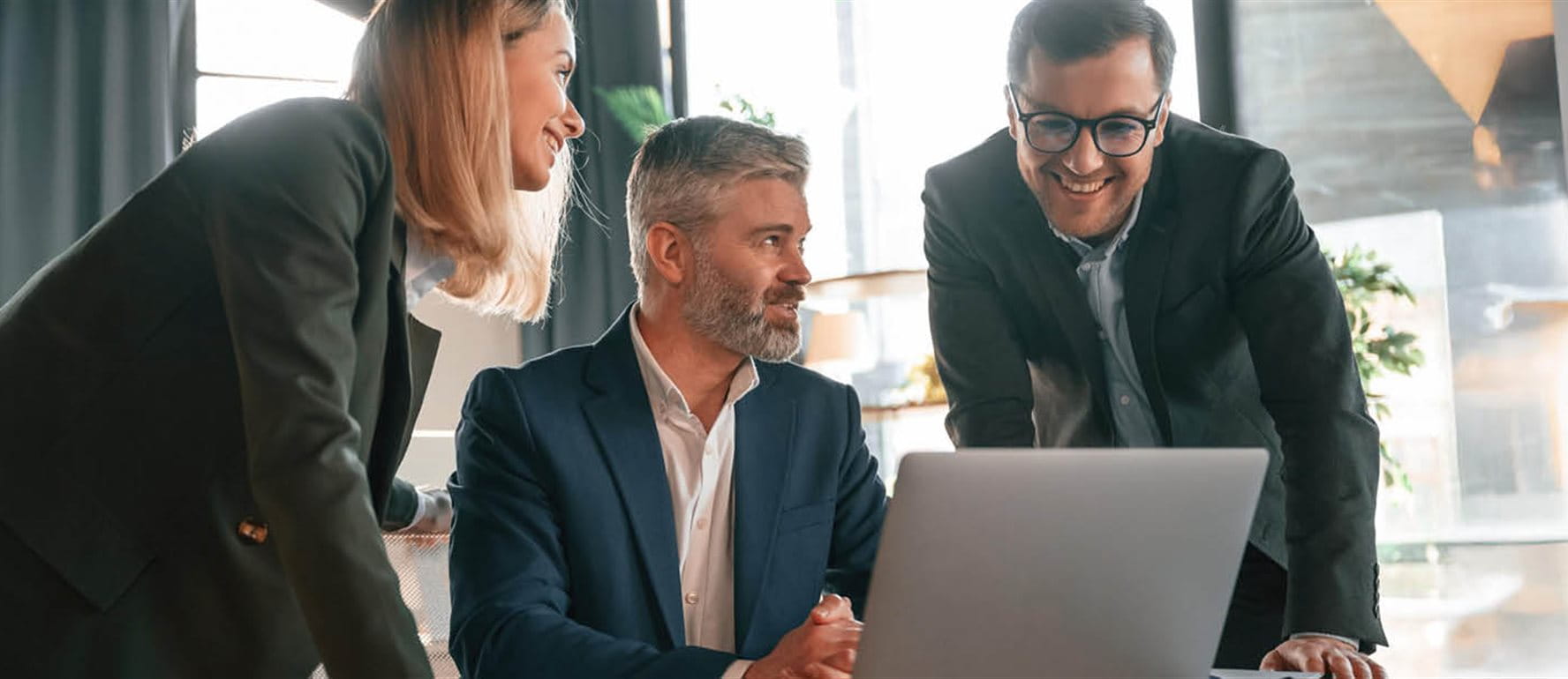 Three people looking into a laptop Three people looking into a laptop