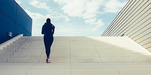 Woman runs up the stairs with a flourish Woman runs up the stairs with a flourish