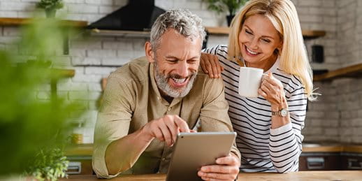A couple is looking something up on a tablet in the kitchen A couple is looking something up on a tablet in the kitchen