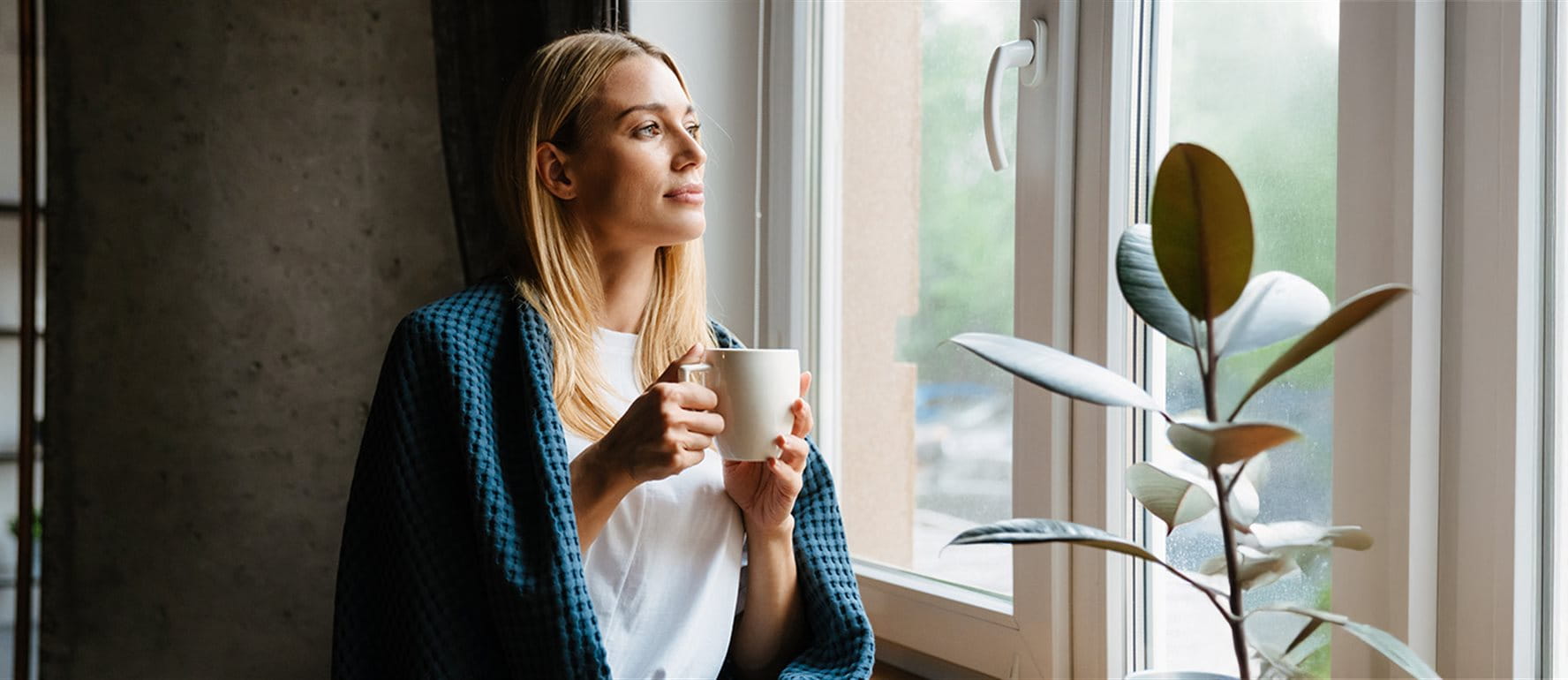 Woman sitting around window with tea Woman sitting around window with tea