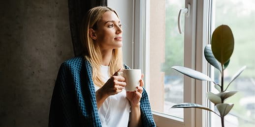 Woman sitting around window with tea Woman sitting around window with tea