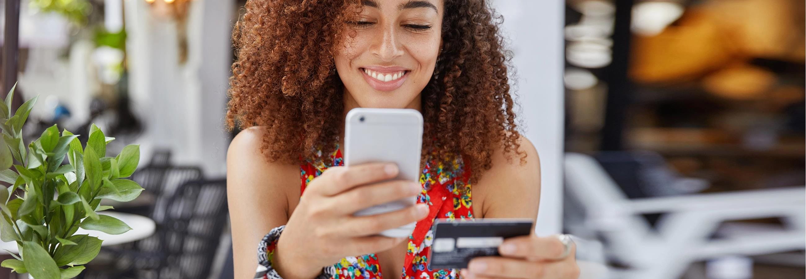 Woman is on cell phone and holding credit card Woman is on cell phone and holding credit card