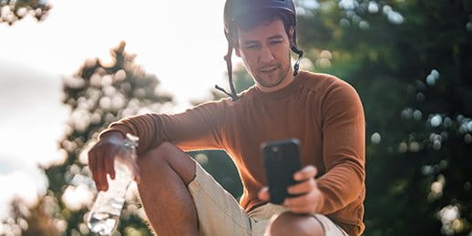 Skater is looking at his smartphone. Skater is looking at his smartphone.