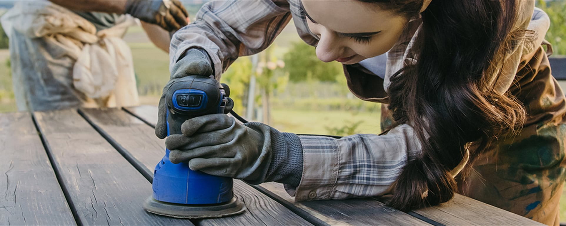 Frau schleift einen Tisch ab Frau schleift einen Tisch ab