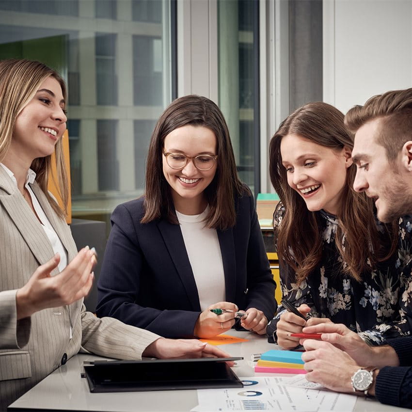 Young Professionals stand around a table and work together to come up with an innovative solution. Young Professionals stand around a table and work together to come up with an innovative solution.