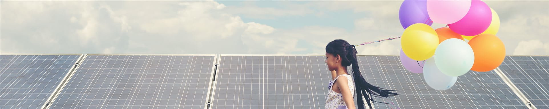 Kind mit Luftballons vor Solarpanels Kind mit Luftballons vor Solarpanels